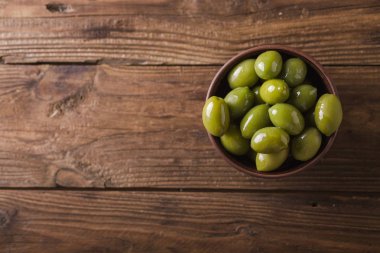 Yeşil zeytin ahşap arka plan üzerinde bir seramik kase. Zeytin arka plan. Yeşil Zeytin ile arka plan. Zeytin. Boşaltmak