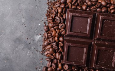 Çikolata ve kahve fasulye. Koyu çikolata arka plan. Çikolata gri arka plan üzerinde büyük bir bar. Çikolata ile arka plan. 