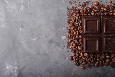 Çikolata ve kahve fasulye. Koyu çikolata arka plan. Çikolata gri arka plan üzerinde büyük bir bar. Çikolata ile arka plan. 