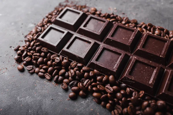 Schokolade und Kaffeebohnen. Dunkle Schokolade Hintergrund. eine große Tafel Schokolade auf grauem abstrakten Hintergrund. Hintergrund mit Schokolade. — Stockfoto
