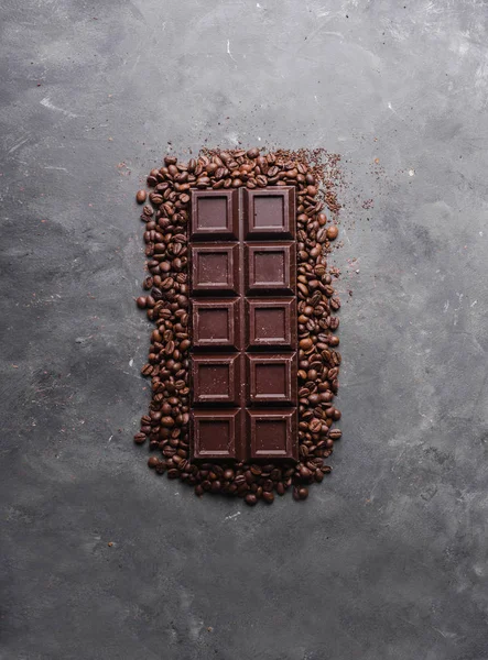Chocolade en koffie bonen. Donkere chocolade achtergrond. Een grote bar van chocolade op grijze abstracte achtergrond. Achtergrond met chocolade. — Stockfoto