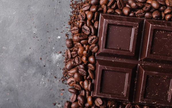 巧克力和咖啡的咖啡豆。黑巧克力的背景。一大块巧克力灰色抽象背景。背景与巧克力. — 图库照片