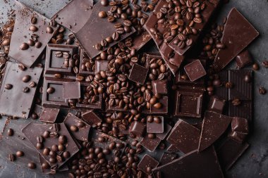 Kahve çekirdekleri çikolata koyu çikolata ile. Çikolata kırık dilim. Çikolata parçaları bar. Çikolata gri arka plan üzerinde büyük bir bar. Kahve çekirdekleri. 