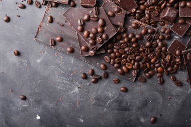 Kahve çekirdekleri çikolata koyu çikolata ile. Çikolata kırık dilim. Çikolata parçaları bar. Çikolata gri arka plan üzerinde büyük bir bar. Kahve çekirdekleri.