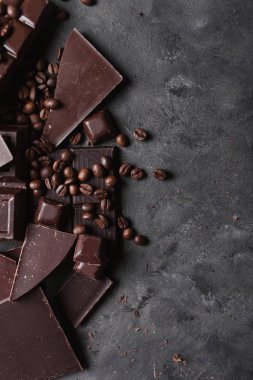 Kahve çekirdekleri çikolata koyu çikolata ile. Çikolata kırık dilim. Çikolata parçaları bar. Çikolata gri arka plan üzerinde büyük bir bar. Kahve çekirdekleri.