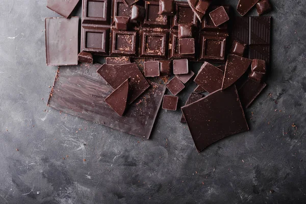 Chocolade chocolade stukjes. Chocolade bar stukken. grote bar van chocolade op houten achtergrond. Chocolade snoepjes. — Stockfoto