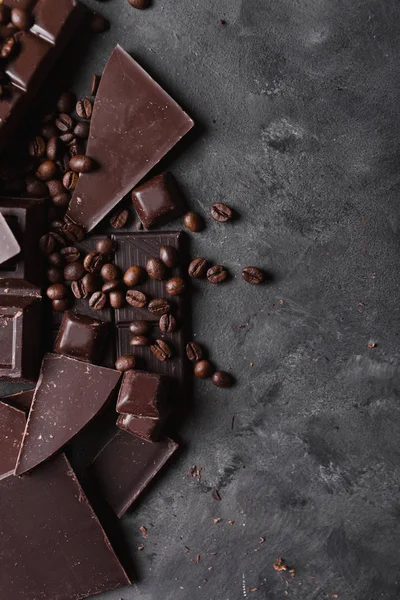 Koffiebonen met chocolade Pure chocolade. Gebroken segmenten van chocolade. Chocolade bar stukken. Een grote bar van chocolade op grijze abstracte achtergrond. Koffiebonen. — Stockfoto