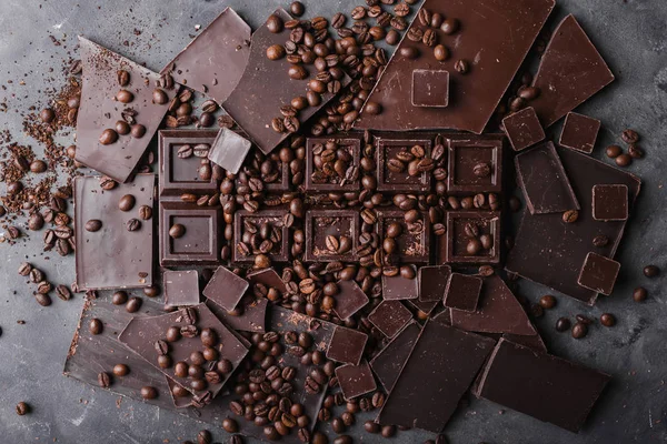 Koffiebonen met chocolade Pure chocolade. Gebroken segmenten van chocolade. Chocolade bar stukken. Een grote bar van chocolade op grijze abstracte achtergrond. Koffiebonen. — Stockfoto
