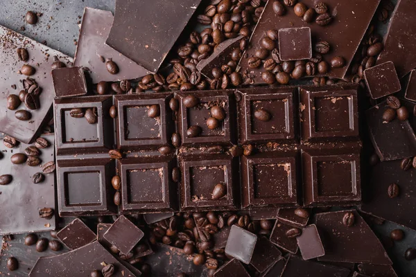 Kaffeebohnen mit dunkler Schokolade. Scherben von Schokolade. Schokoriegel. eine große Tafel Schokolade auf grauem abstrakten Hintergrund. Kaffeebohnen. — Stockfoto