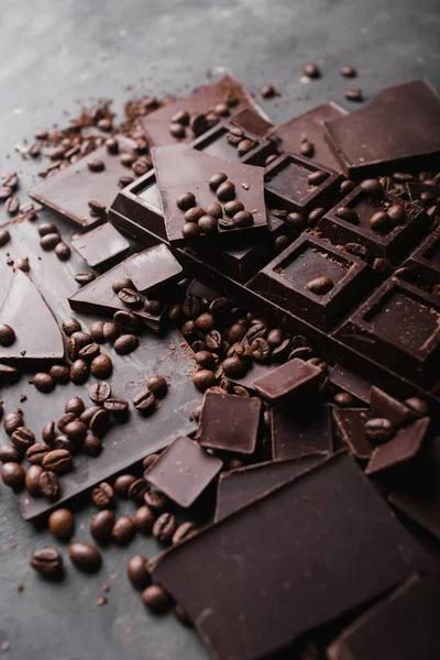 Kaffeebohnen mit dunkler Schokolade. Scherben von Schokolade. Schokoriegel. eine große Tafel Schokolade auf grauem abstrakten Hintergrund. Kaffeebohnen. — Stockfoto