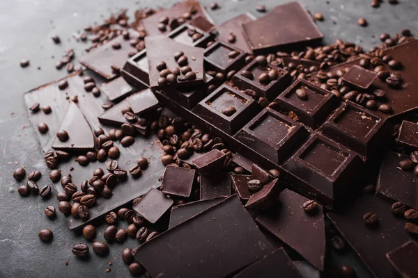 Koffiebonen met chocolade Pure chocolade. Gebroken segmenten van chocolade. Chocolade bar stukken. Een grote bar van chocolade op grijze abstracte achtergrond. Koffiebonen. — Stockfoto