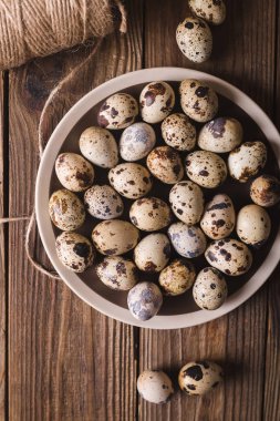Bıldırcın yumurtası kahverengi bir plaka üzerinde ahşap bir masa. Rustik tarzı. Yumurta. Paskalya fotoğraf kavramı. Boşaltmak 