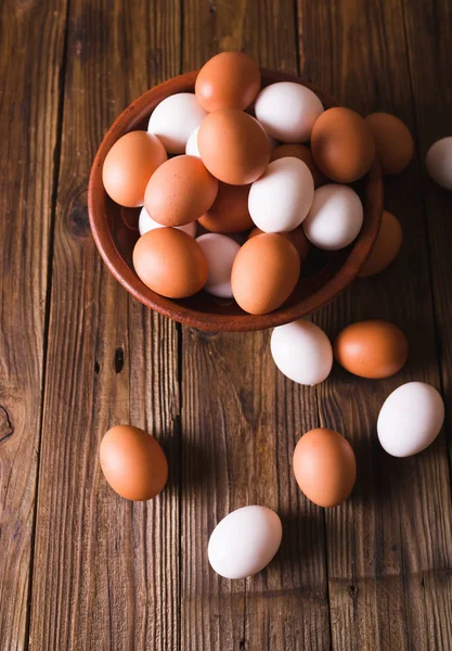 木製の背景上にセラミック ボウルに白と茶色の卵。素朴なスタイル。卵。イースターの写真の概念。Copyspace — ストック写真