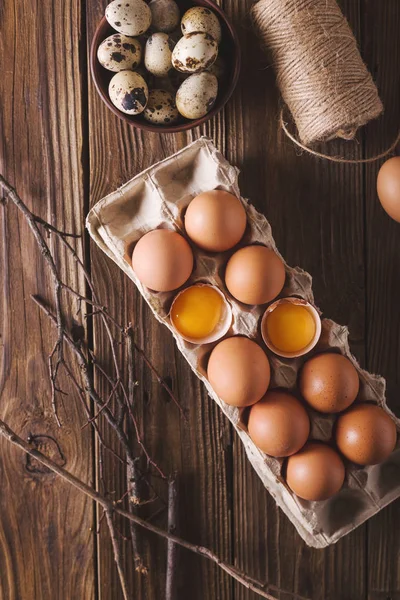 Paket ahşap arka plan üzerinde kırık yumurta ve yumurta. Un üzerinde ahşap bir masa dağıldı. Yumurta kabuğu. Fotoğraf kavramı pişirme — Stok fotoğraf