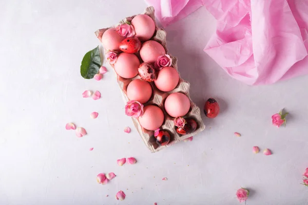 Pink Easter eggs on light background. Copyspace. Still life photo of lots of pink easter eggs.Background with easter eggs. Pink eggs and roses. Easter photo concept