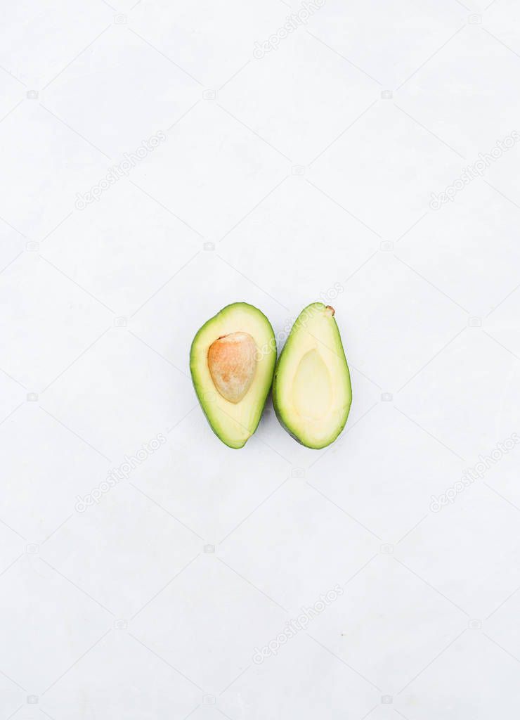 halves of avocado on white