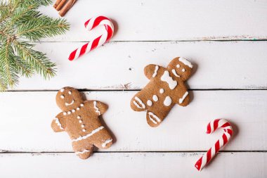 Noel arka plan. Zencefilli kurabiye adam ve Beyaz ahşap zemin üzerinde Noel kamışı