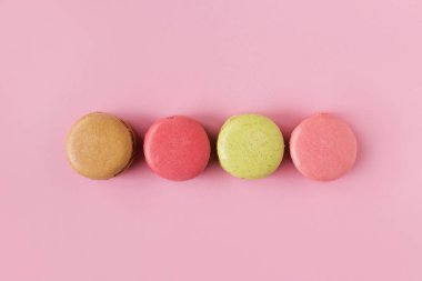 renkli badem macaroons pembe bir arka plan, pastel renkler, vintage kartı, üstten görünüm