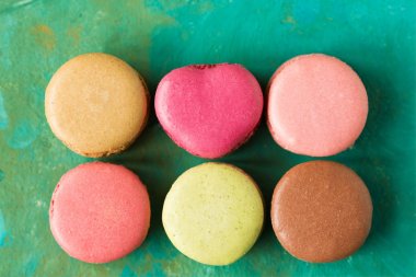 renkli badem macaroons yeşil arka plan, pastel renkler, vintage kartı, üstten görünüm