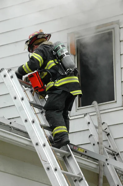 Firefighter climbing ladder — ストック写真