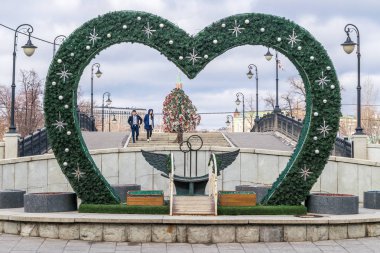 MOSCOW, RUSSIA - FEBRUARY 26, 2017: The bench of reconciliation for honeymooners with Christmas and New Year decoration near Luzhkov bridge. clipart