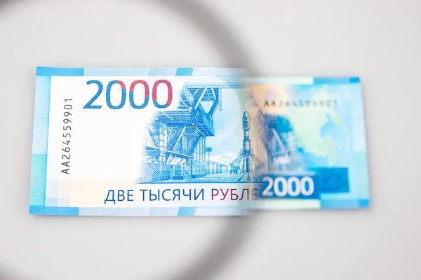 Dos mil rublos de billetes a través de una lupa — Foto de Stock