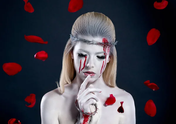 girl with a bloody face, with white skin and a wreath on her head. barbed wire
