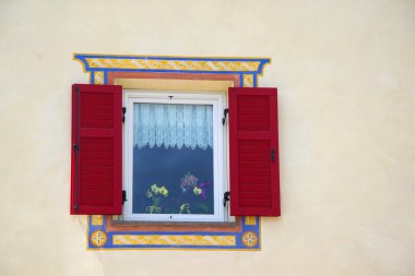 Küçük Alp ülkede evde kırmızı panjurlar ile güzel pencere