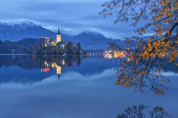 Bled lago y la iglesia de peregrinación en el crepúsculo reflejado en el agua — Foto de Stock