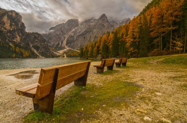 Ön plan üzerinde banklar ile Braies Gölü'nün doğal görünümü