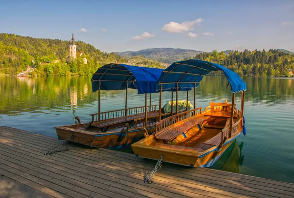 Touristenboote aus Holz, die an der Seebrücke am slowenischen See festgemacht haben — Stockfoto