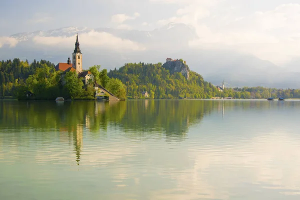 Lac de Bled et église de pèlerinage avec fond de paysage de montagne de printemps — Photo