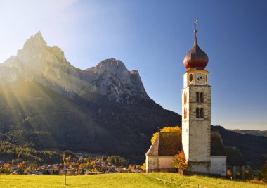 Geleneksel Tyrol kilise sonbahar güneşi altında Dolomites eteklerinde