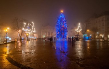 Işıklı Noel ağacı sisli akşam kasaba meydanında