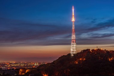 Yüksek Kale Tepesi 'nin muhteşem panoramik manzarası alacakaranlıkta aydınlanan TV kulesiyle gün batımının muhteşem gökyüzü Lviv, Ukrayna' ya karşı. UNESCO dünya mirası sahası