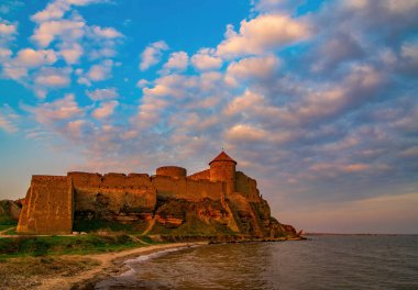 Ukrayna 'nın Odesa bölgesindeki Bilhorod-Dnistrovskyi' deki Ortaçağ Akkerman Kalesi 'nde muhteşem bir sabah. Güneşin doğuşuyla aydınlanan yanan bulutlar.