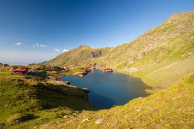 Güneşli bir günde Transfagarasan Balea Buzul Gölü manzarası. Romanya 'nın en çok ziyaret edilen simgelerinden birinin inanılmaz yaz manzarası
