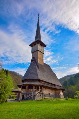 Romanya 'nın Barsana manastırındaki geleneksel Maramures neo gotik ahşap kilise. Resimli gökyüzü