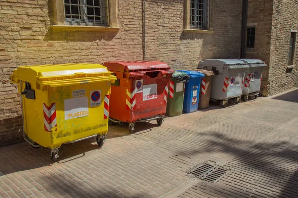 Various containers for garbage in a street in Urbino