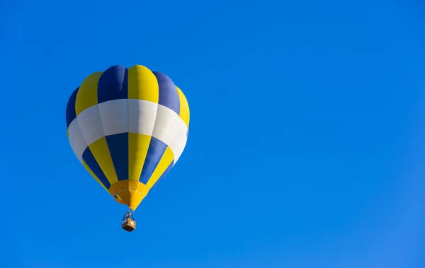 青空の中で孤独な飛行で黄色と青の熱気球 — ストック写真