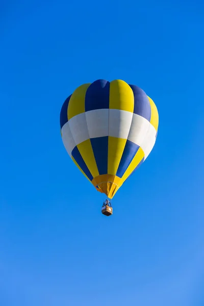 青空の中で孤独な飛行で黄色と青の熱気球 — ストック写真