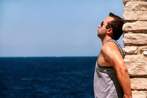 Adam bir düşünme eğilimi deniz duvarda — Stok fotoğraf
