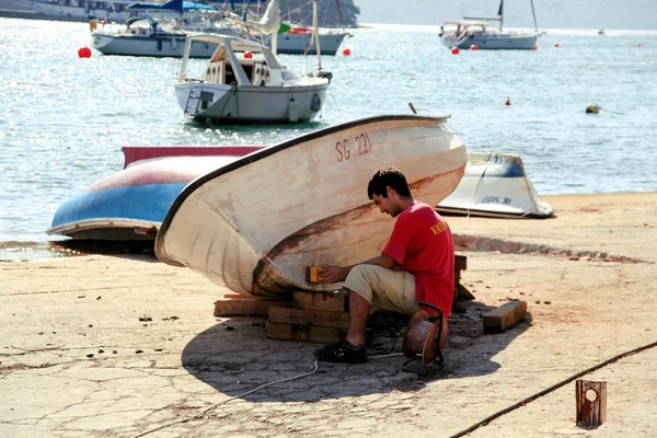 Hombre pintura barco de pesca en el puerto — Foto de Stock