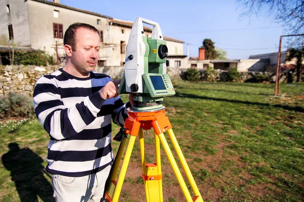 Surveyor worker making measurement in the garden, total station