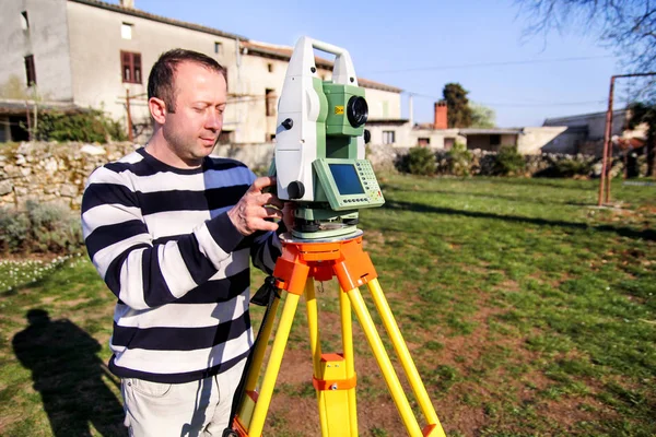 Surveyor worker making measurement in the garden, total station