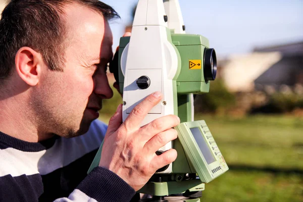 Landmeter werknemer waardoor de meting in de tuin, totaal station — Stockfoto