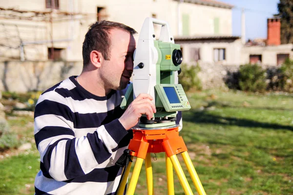 Landmeter werknemer waardoor de meting in de tuin, totaal station — Stockfoto