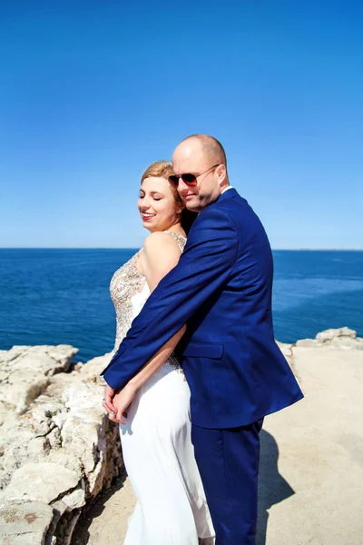 Alegre pareja casada de pie en la playa —  Fotos de Stock