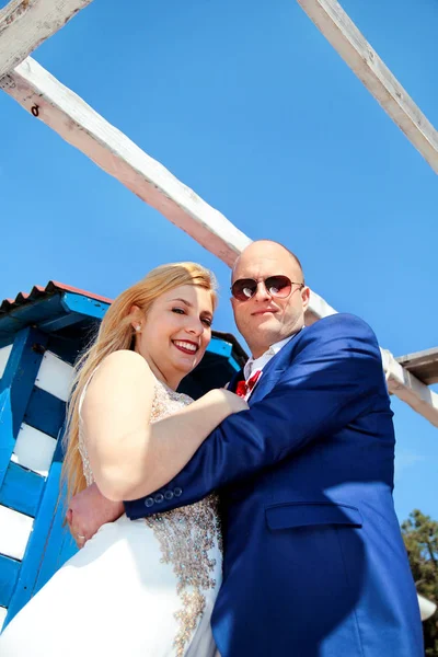 Pareja de boda alojada al lado de la casa blanca azul —  Fotos de Stock