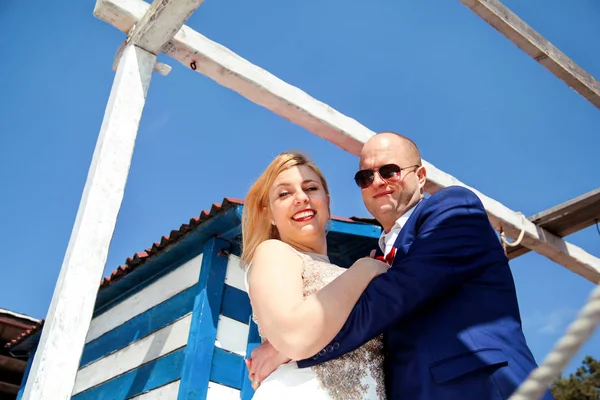 Pareja de boda alojada al lado de la casa blanca azul —  Fotos de Stock